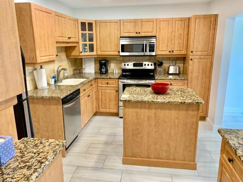 a large kitchen with wooden cabinets and appliances at Newly remodeled 2br, 2ba condo in Naples Bath and Tennis in Naples