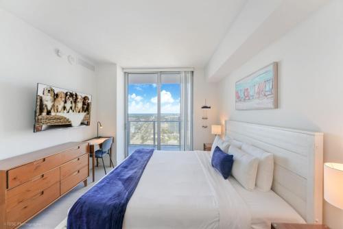 a bedroom with a bed and a desk and a window at Breathtaking 35th Floor 1 BDR in Hyde Beach House in Hollywood