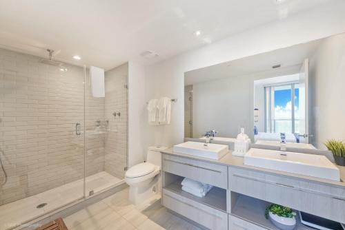 a bathroom with two sinks and a shower and a toilet at Breathtaking 35th Floor 1 BDR in Hyde Beach House in Hollywood