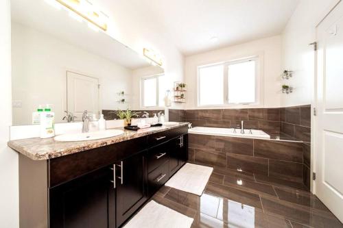 a large bathroom with two sinks and a tub at 3B Executive Home - All King Beds - Fireplace - Garage in Edmonton