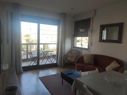 ein Wohnzimmer mit einem Sofa und einem Tisch in der Unterkunft Apartamento Playa Ladeira in Baiona