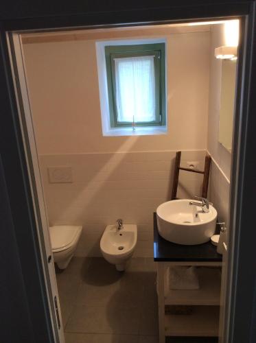 a bathroom with a sink and a toilet and a window at Il Bosso del Lago in Ameno