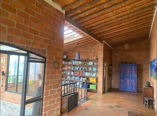 Zimmer mit Ziegelwand und Bücherregal in der Unterkunft Las Mañanitas Habitación Boreal in Medellín