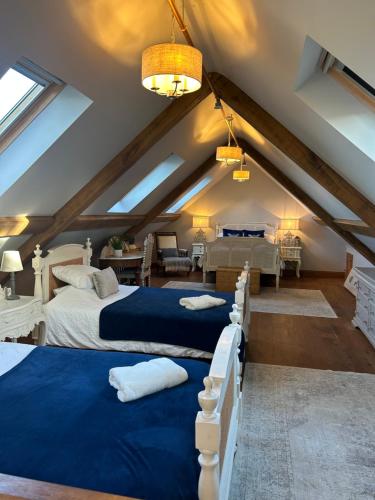 a attic bedroom with two beds and a living room at Hideaway Barn Coltishall in Coltishall