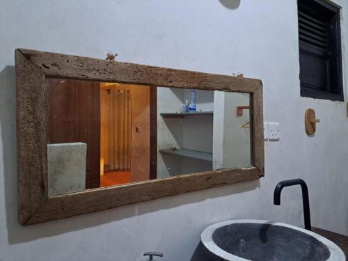 un bagno con specchio sopra un lavandino di Pwani House - Lamu Seafront a Lamu