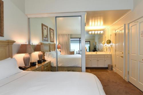 1 dormitorio con cama blanca y espejo en Getaway Suite at Silverado in Napa, en Napa