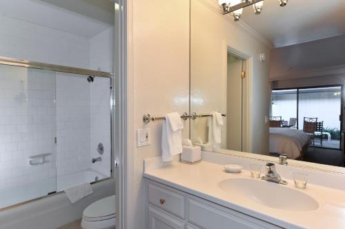a bathroom with a sink and a toilet and a mirror at Getaway Suite at Silverado in Napa in Napa