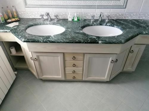 a bathroom with two sinks and a marble counter at La casa degli ulivi in Turri