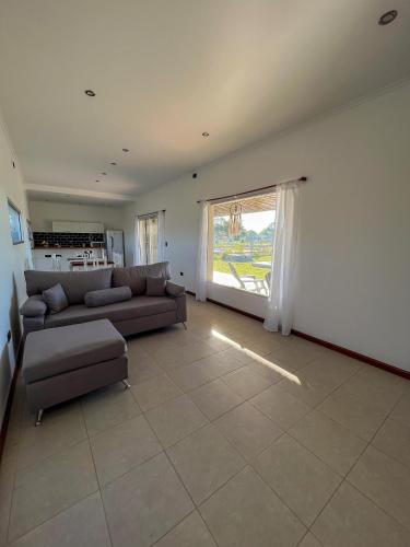 - un salon avec un canapé et une grande fenêtre dans l'établissement Casa quinta con entorno rural, à Chacabuco