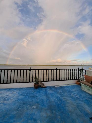 a rainbow in the sky over the water on a balcony at Pwani House - Lamu Seafront in Lamu