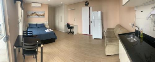 a bedroom with a bed and a kitchen and a living room at Loft 2 Completo próx GRU airport in Guarulhos