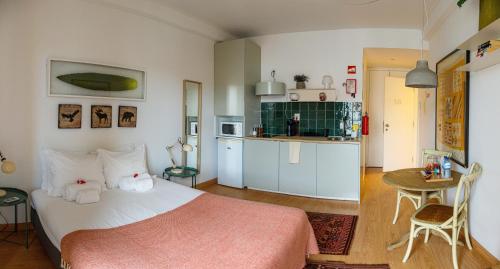 a bedroom with a bed and a small kitchen at O Quinto Esquerdo in Lisbon