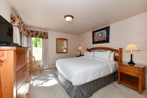 1 dormitorio con 1 cama blanca y TV en Perfect Wine Country Retreat at Silverado, en Napa