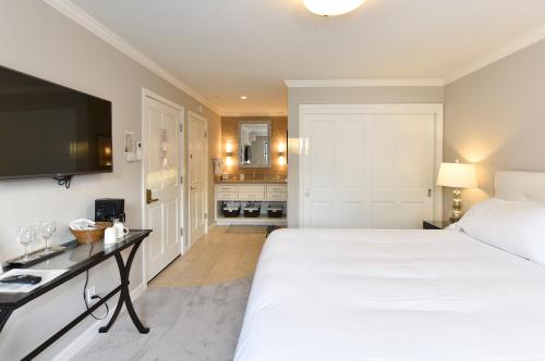 a bedroom with a large white bed and a television at High-end Getaway Suite at Silverado in Napa