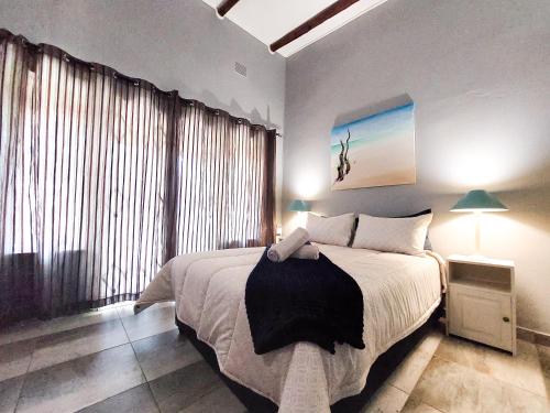 a bedroom with a large bed and a large window at Lagoon Cabanas in Ramsgate