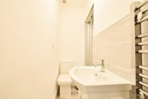 a white bathroom with a sink and a toilet at 46 Havelock Street in Kettering