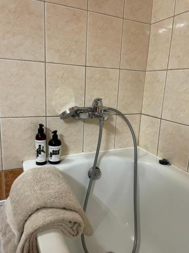 a bath tub with a towel on the side of it at Prostě Terezská in Olomouc