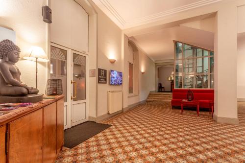 a lobby with a red couch and a chair at Providence Hotel in Vittel