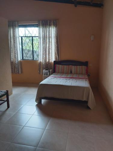 ein Schlafzimmer mit einem Bett und einem großen Fenster in der Unterkunft Casa Moa in Tena