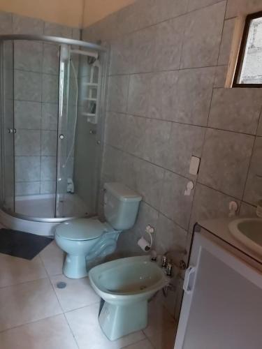 ein Badezimmer mit 2 WCs, einer Dusche und einem Waschbecken in der Unterkunft Casa Moa in Tena