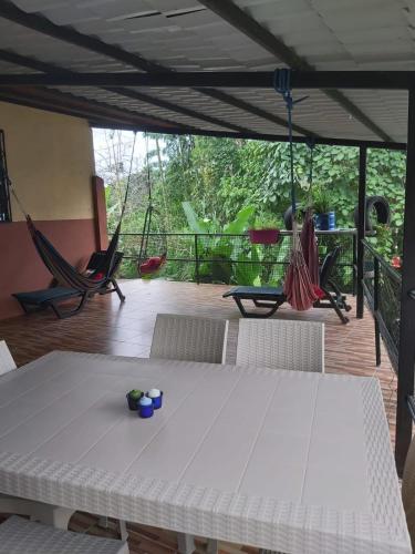 Zimmer mit einem Tisch und Hängematten auf einer Terrasse in der Unterkunft Casa Moa in Tena