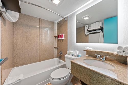 a bathroom with a sink and a toilet and a tub at SureStay Studio by Best Western Virginia Beach Oceanfront in Virginia Beach