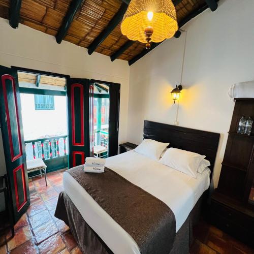 a bedroom with a large bed and a large window at Hotel Boutique Samay in Duitama
