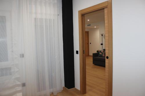 a door leading into a living room with white curtains at Fernando Quero 21 in Andújar