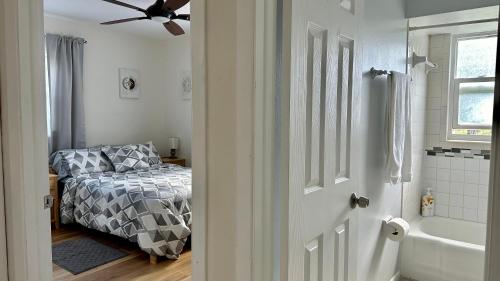 a bedroom with a bed and a bathroom with a ceiling fan at Cozy Rooms near Busch Gardens in Tampa
