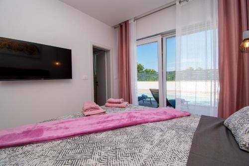 - une chambre avec un grand lit et une grande fenêtre dans l'établissement Ferienhaus Beata mit privatem Pool in Istrien,Vodnjan, à Svetvinčenat