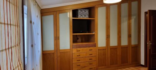 a room with a entertainment center with a television in it at Loft Teis in Vigo