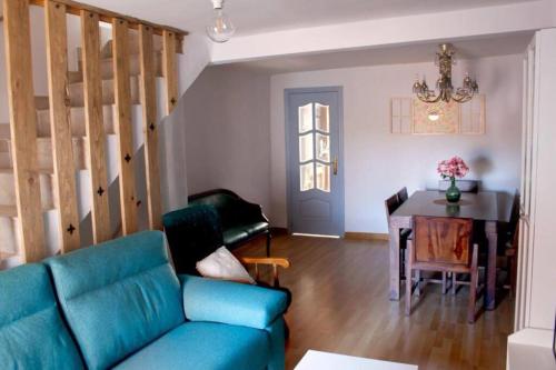 a living room with a blue couch and a table at La casa de la Golondrina in Pedro Bernardo