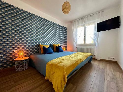 a bedroom with a king sized bed with a yellow blanket at Rés. Marie Galante, Lac du Der 