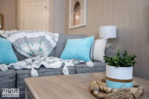 a living room with a couch and a table with a plant at Boho Suite - Long Stays - King Bed - Fireplace & WiFi in Edmonton