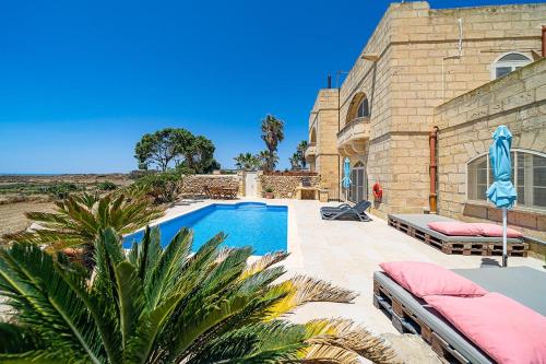 une maison avec une piscine à côté d'un bâtiment dans l'établissement Ta' Lonza Farmhouse, à L-Għarb