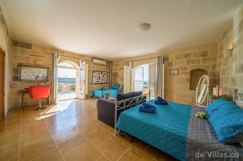 ein Schlafzimmer mit einem Bett und einem Sofa in einem Zimmer in der Unterkunft Ta' Lonza Farmhouse in Għarb