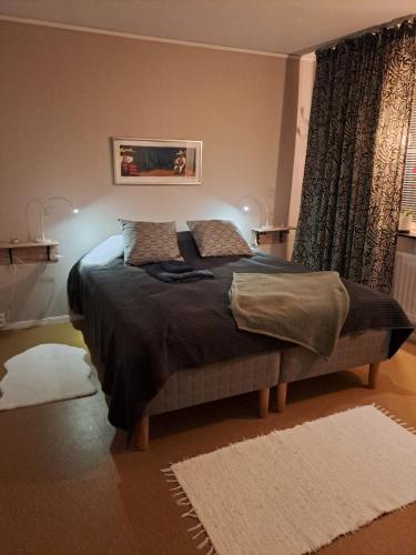 um quarto com uma cama grande e 2 almofadas em Klockestrandstugan-Höga kusten em Kramfors