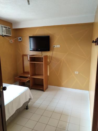 a room with a tv and a bed in a room at Divino Niño Hotel in Leticia