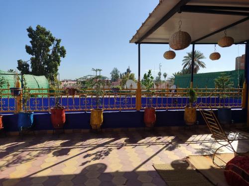 eine Terrasse mit einem blauen Zaun und Topfpflanzen in der Unterkunft Riad dar sahrawi in Marrakesch