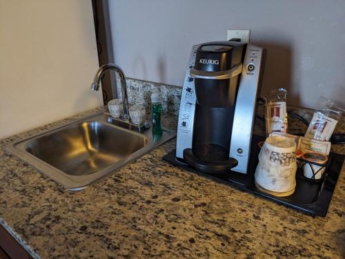 a kitchen counter with a coffee maker next to a sink at GrandStay Residential Suites Hotel in Saint Cloud