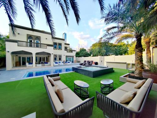 an exterior view of a house with a pool and lawn at Royal private pool, Lux 7-bedroom villa on Marina in Dubai