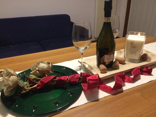 a table with a green plate and a bottle of wine at civico 38 in Bassano del Grappa