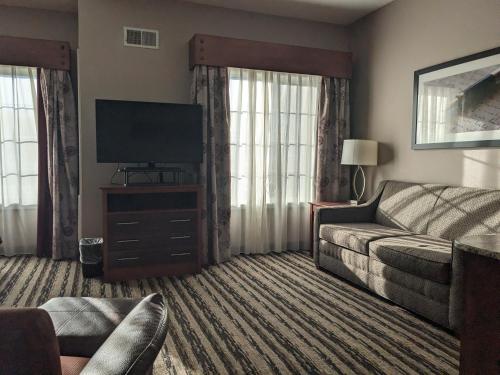 a living room with a couch and a flat screen tv at GrandStay Residential Suites Hotel in Saint Cloud