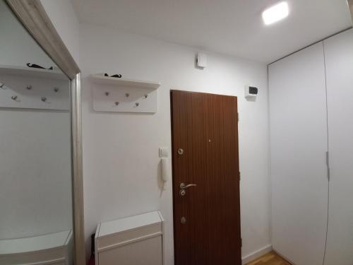 ein Badezimmer mit einem WC und einer Holztür in der Unterkunft Mieszkanie Sobieskiego in Warschau