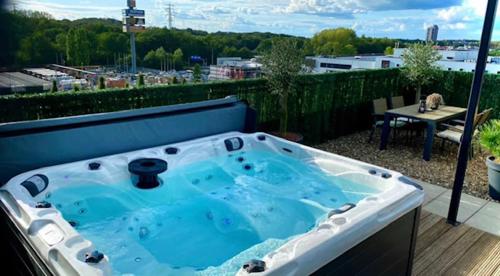 a hot tub on a balcony with a view of a city at Wellness Dome Penthouse in Kerkrade