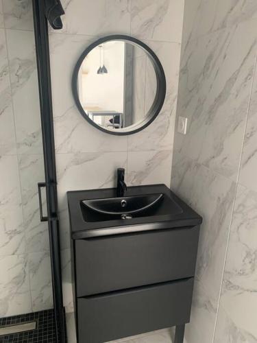 a bathroom with a black sink and a mirror at La chambre de Flore in Arras