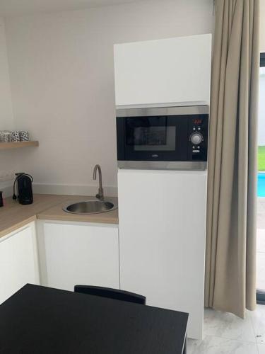 a kitchen with a sink and a microwave at La chambre de Flore in Arras