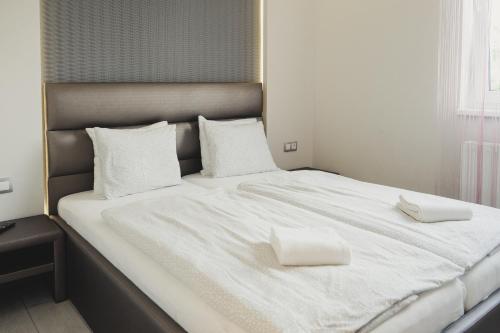 a large bed with two white pillows on it at Harmony Apartments Sárvár in Sárvár