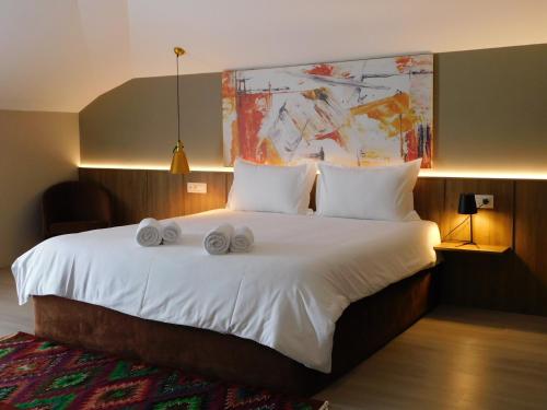 ein Schlafzimmer mit einem großen Bett mit zwei Handtüchern darauf in der Unterkunft MIK Hotel Korce in Korçë