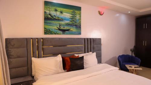 a bedroom with a bed and a painting on the wall at BOL LODGE AND APARTMENT in Lagos